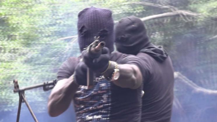 Two masked men aiming guns.