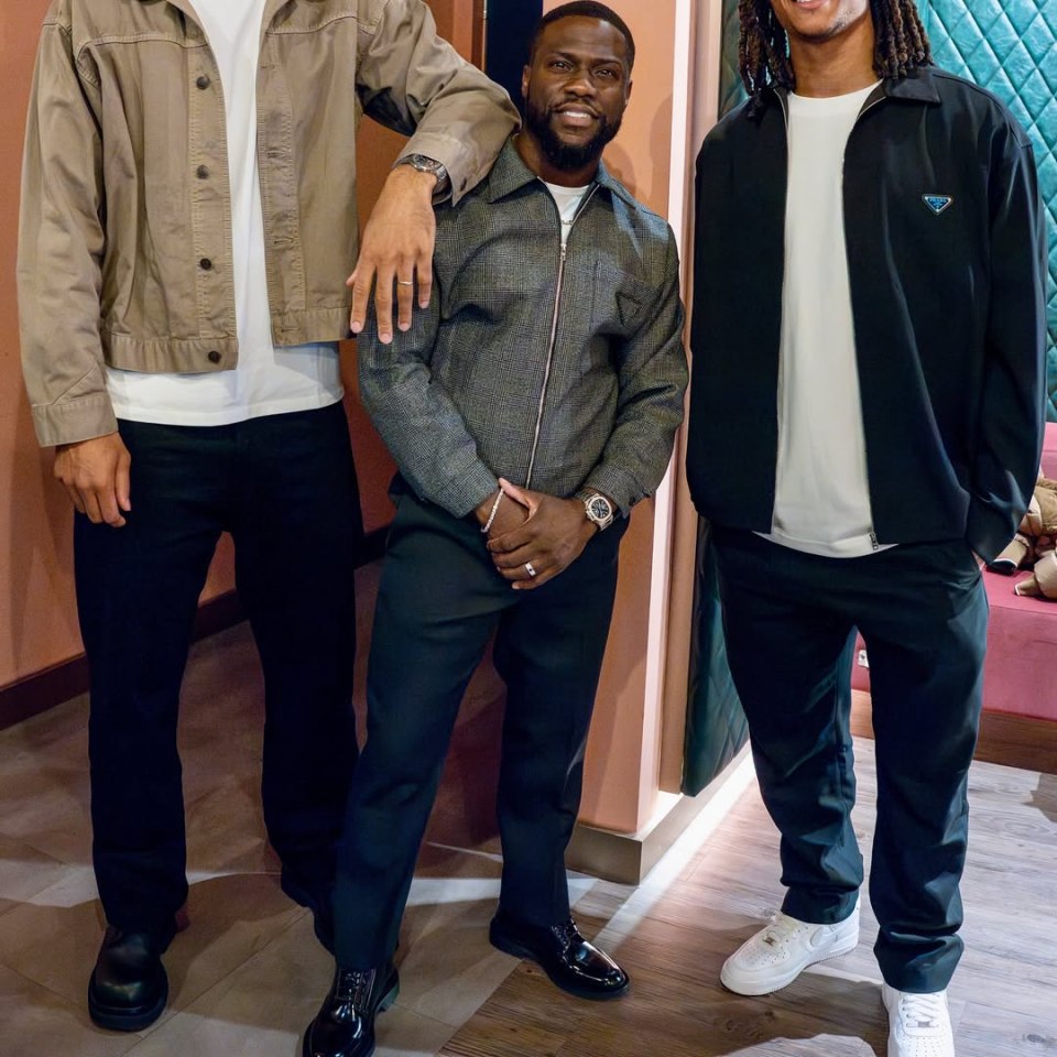 Kevin Hart posing with two taller men.