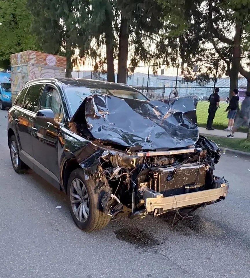 Severely damaged black SUV.