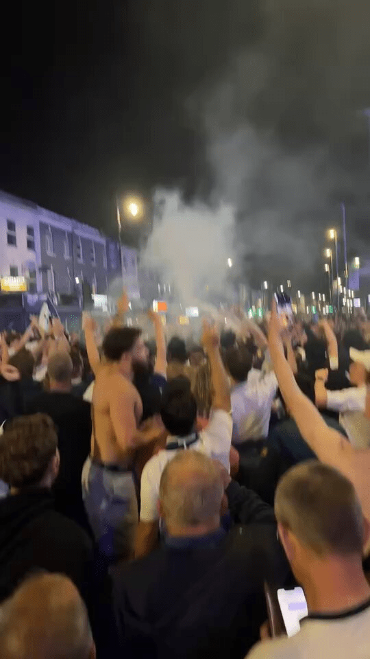 Crowd celebrating with smoke in the air.