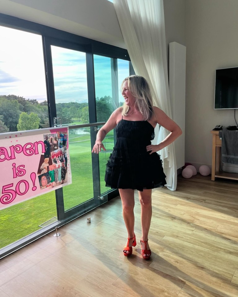 Woman in black dress celebrating a 50th birthday.
