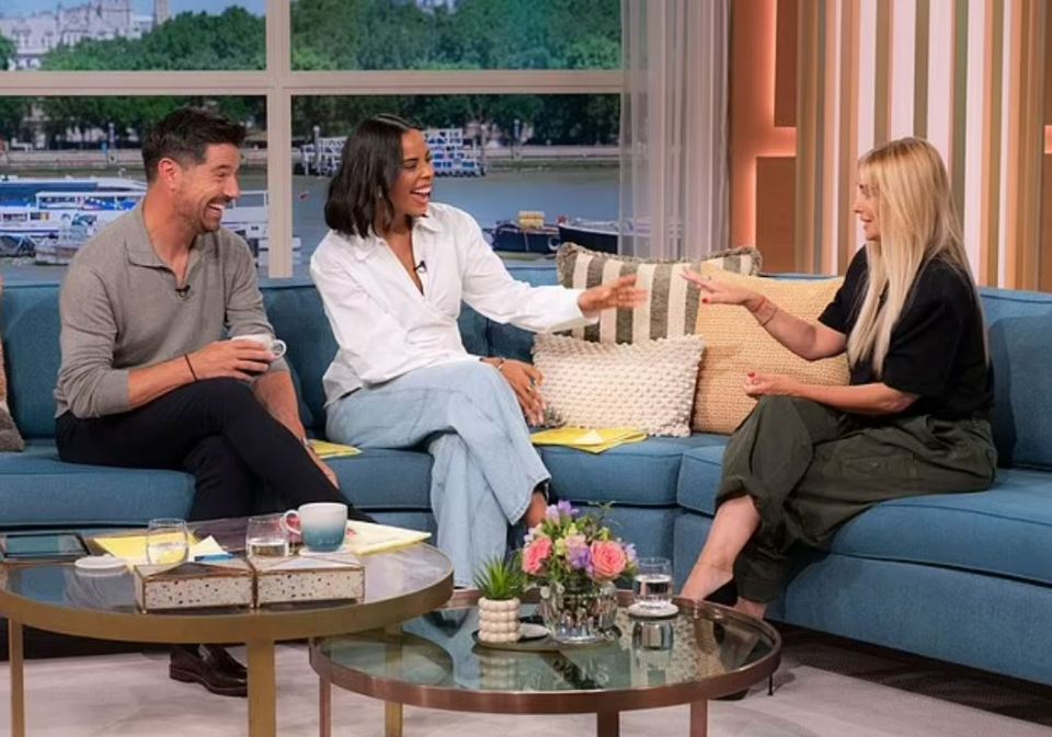 Three people sitting on a couch during a television show.