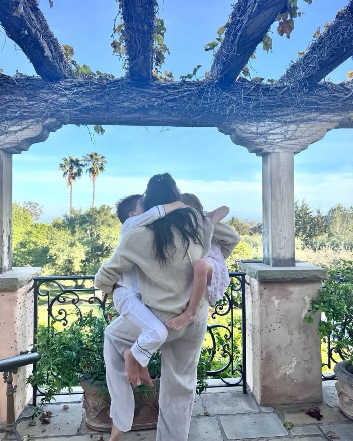 Meghan Markle hugging her children on a balcony.