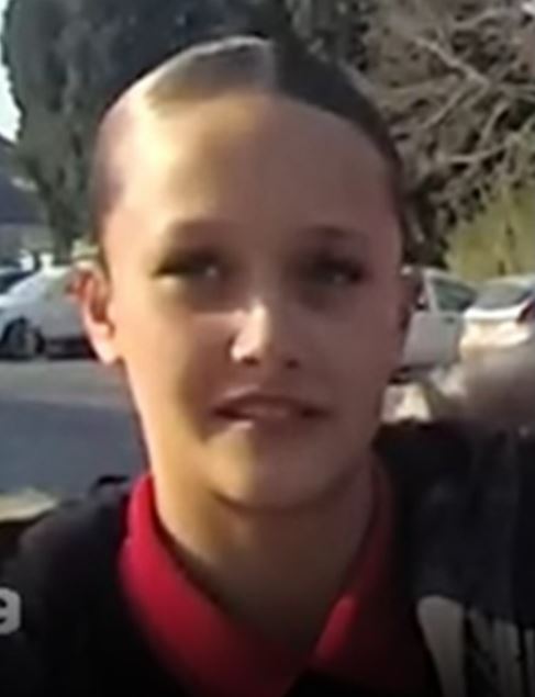 Close-up of a young person with short hair.