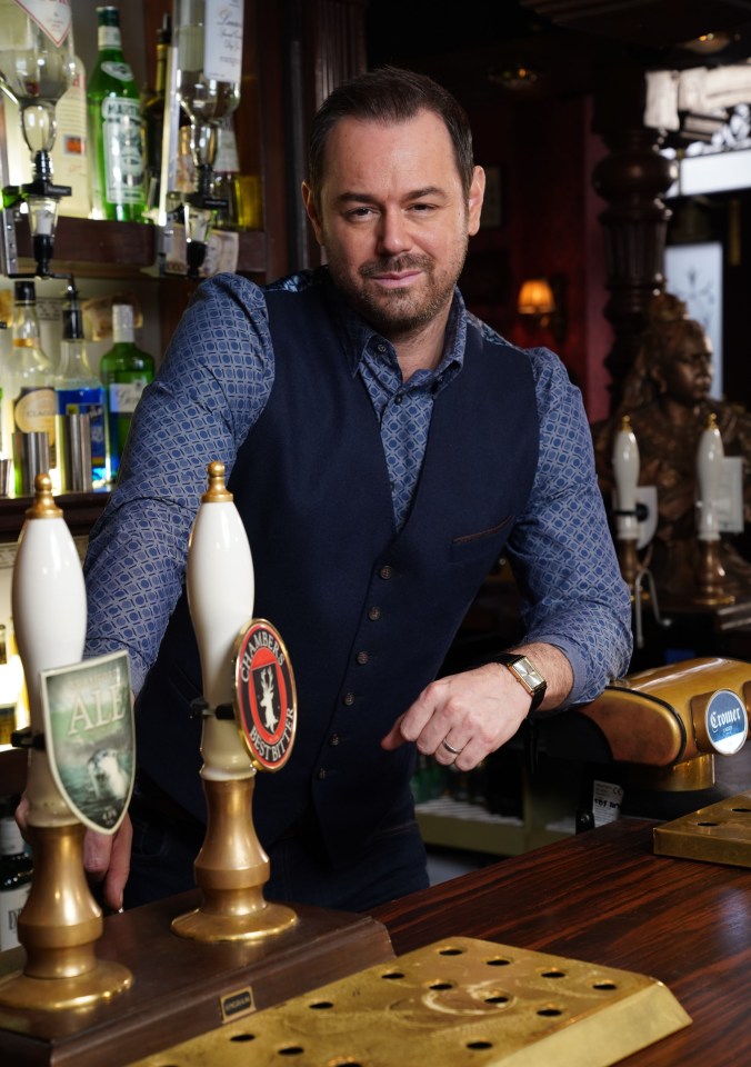 Portrait of Danny Dyer behind a pub bar.