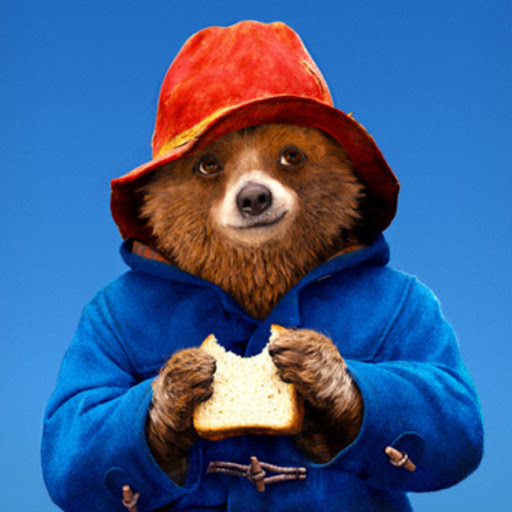 Paddington Bear eating a sandwich.