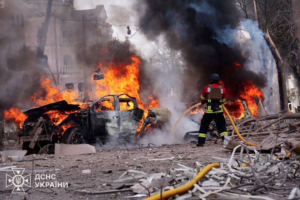 Ukrainian rescuer extinguishing a fire at a missile attack site in Sumy.
