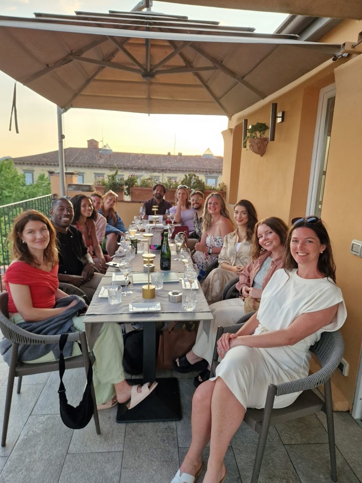 Group of people seated at an outdoor table.