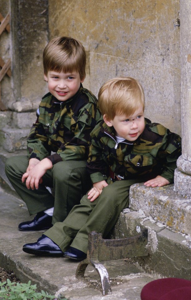 Princes William and Harry in military uniforms sitting together.