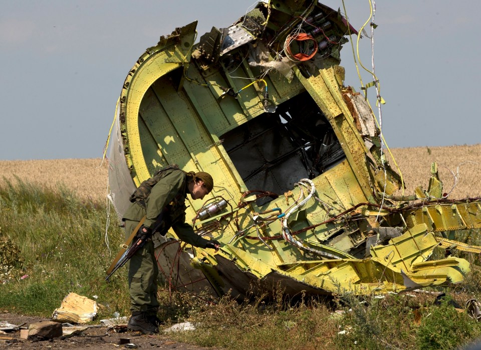 A pro-Russian rebel examines wreckage of Malaysia Airlines Flight 17.