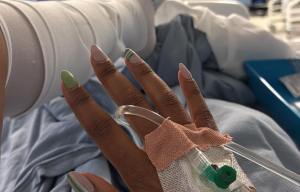 Person in hospital bed with IV drip.