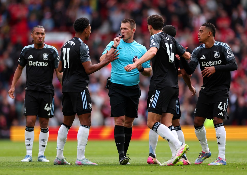 Referee surrounded by Aston Villa players protesting a disallowed goal.