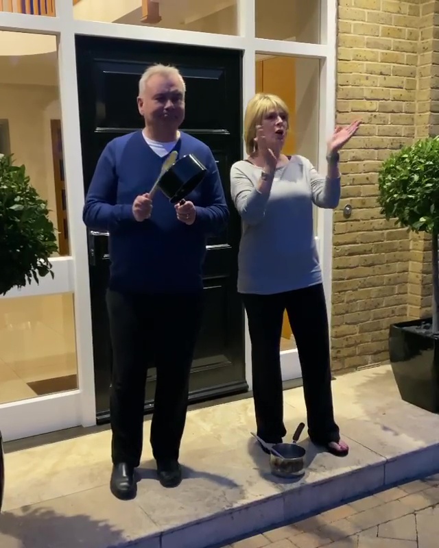 Ruth and Eamonn Langsford clapping with pans outside their home.