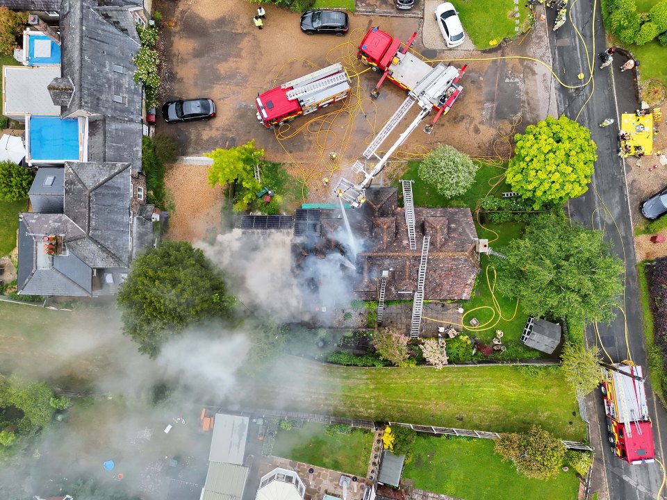 Aerial view of firefighters extinguishing a house fire.