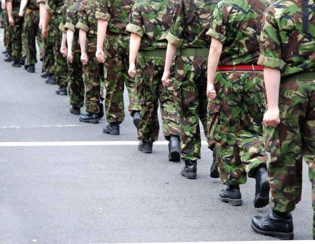Soldiers marching in camouflage uniforms.