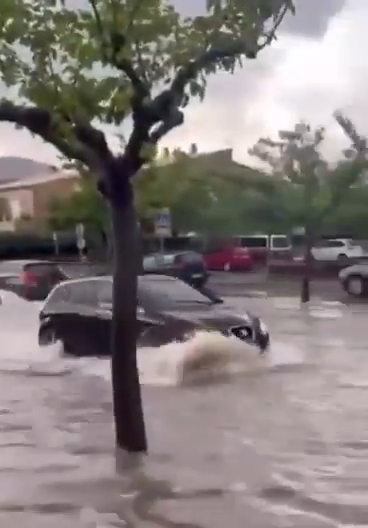 Car driving through flooded street in Porto Cristo, Majorca.