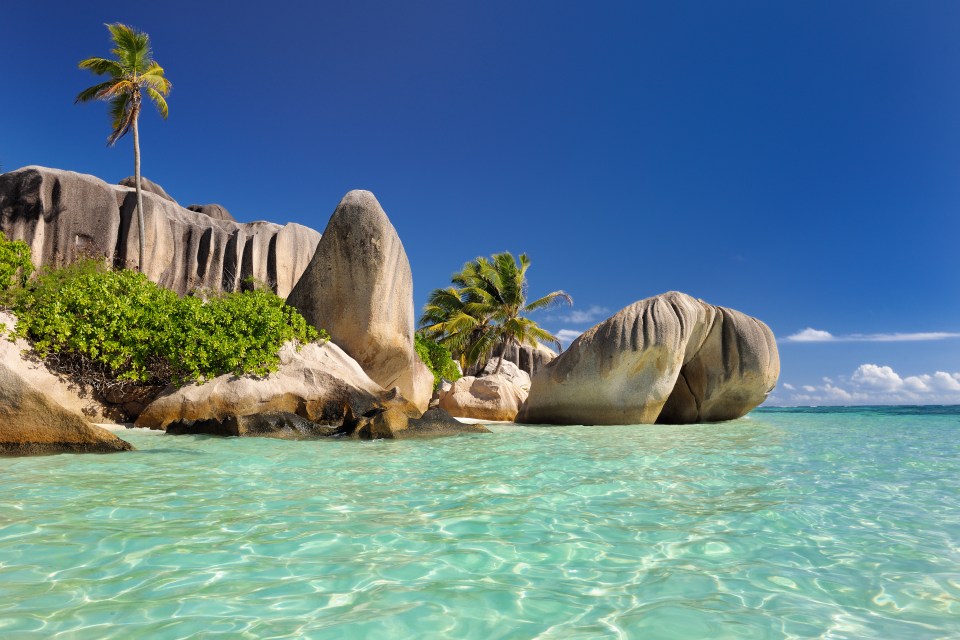 Famous beach Anse Source d'Argent with palm trees, clear water and sculpted rocks, La Digue Island, Seychelles, Indian Ocean