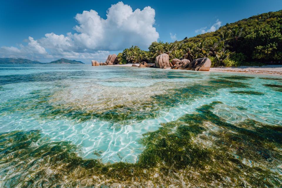 Tropical beach with granite boulders and clear water.