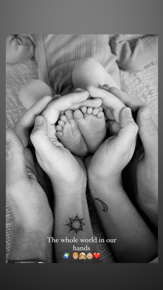Black and white photo of a baby's feet cradled in the hands of two adults.