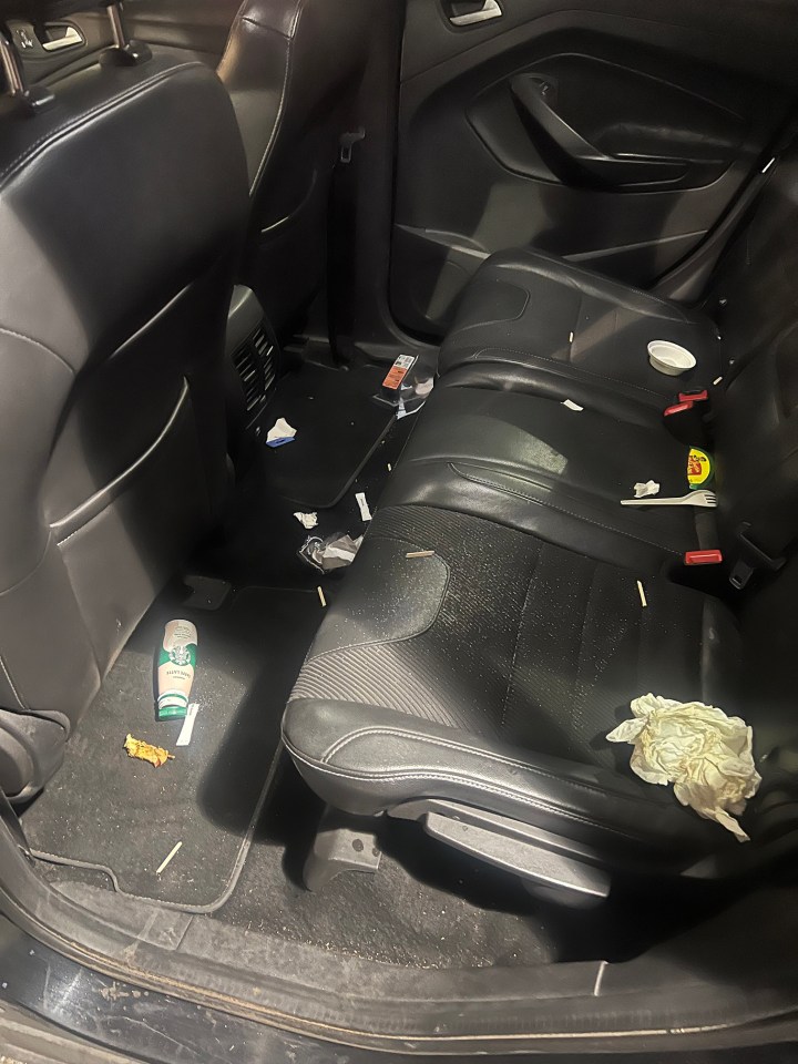 Messy backseat of a car.
