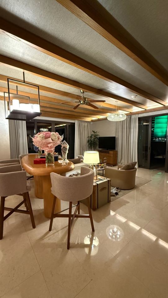 Luxury suite interior with wooden beams, seating area, and dining table.