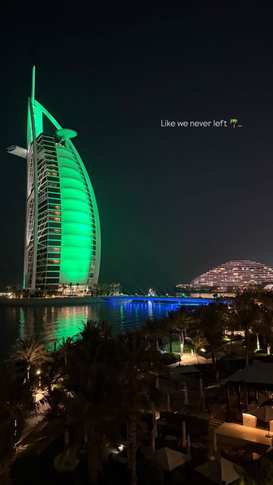 Night view of the Burj Al Arab Jumeirah in Dubai, lit in green.