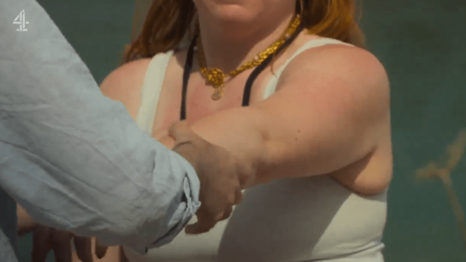 Charlotte and Jason holding hands on a beach.