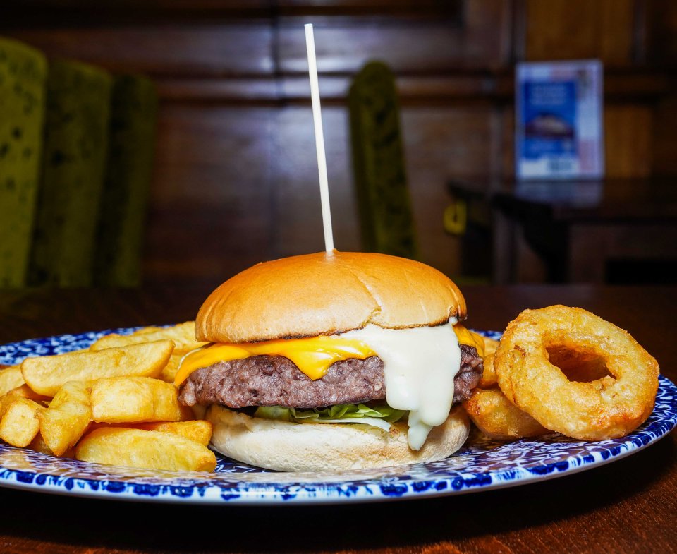 Cheese meltdown burger with fries and onion rings.