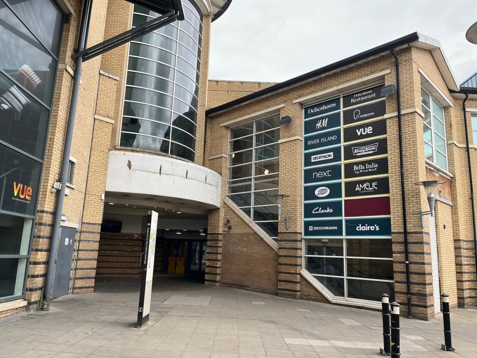 Exterior view of the Grafton Centre in Cambridge, showing various shops.