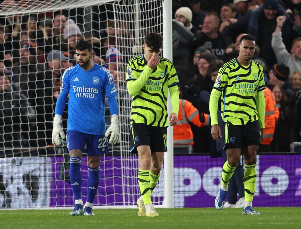 Arsenal players looking dejected after a soccer game.