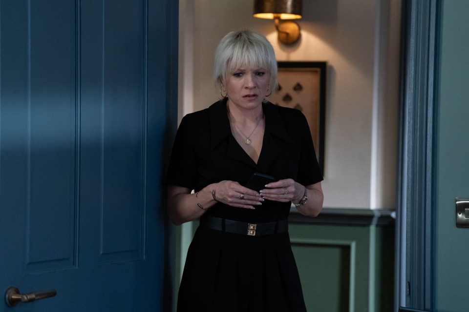 Still image from EastEnders episode 7111 featuring Nicola (Laura Doddington) looking at her phone.
