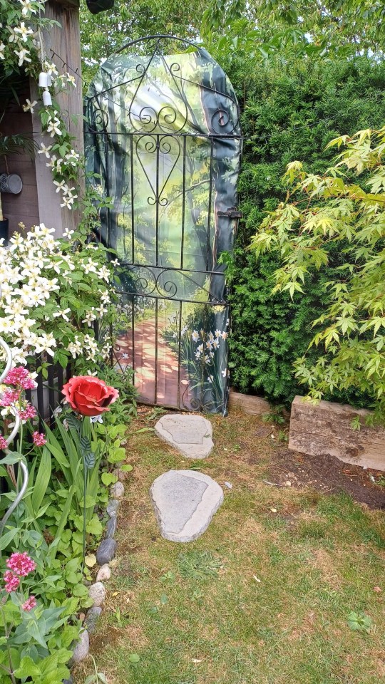 Garden gate with painted woodland scene.