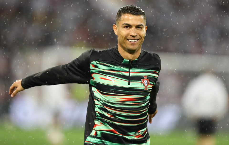 Cristiano Ronaldo of Portugal smiling during a soccer game in the rain.