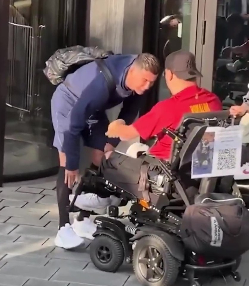 Cristiano Ronaldo helps a fan in a wheelchair.
