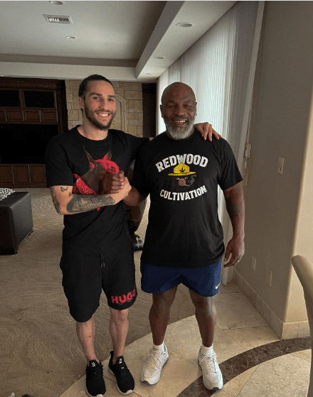 Mike Tyson and a young man posing for a photo.