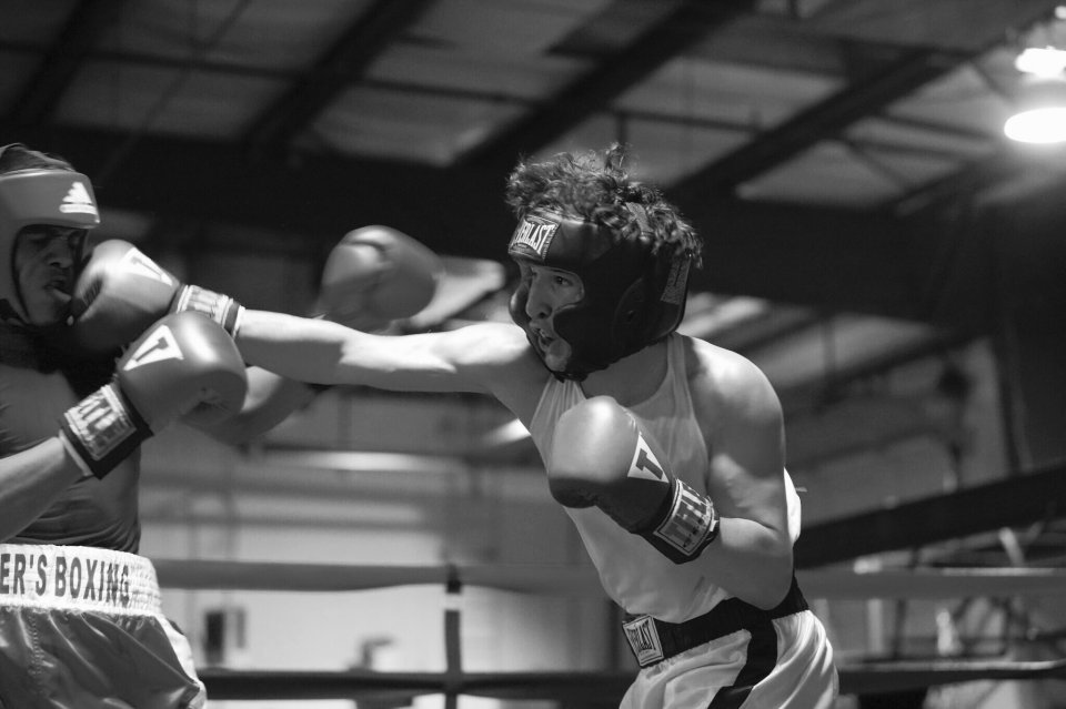 Black and white photo of two boxers sparring in a ring.