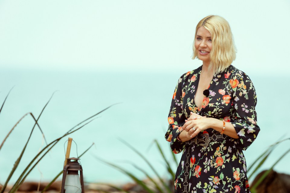 Holly Willoughby on a beach, wearing a floral dress.