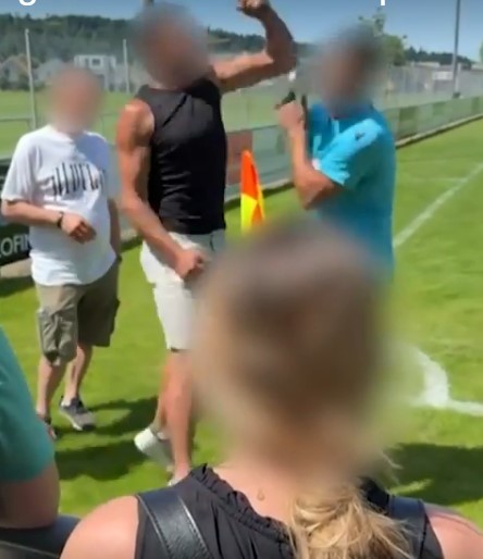 Men arguing on a soccer field.