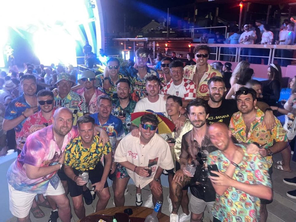 Group of men in Hawaiian shirts at a nightclub.