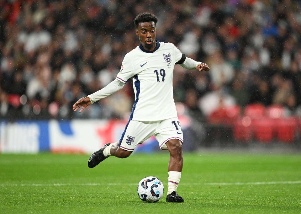 Angel Gomes of England dribbling the ball during a soccer match.