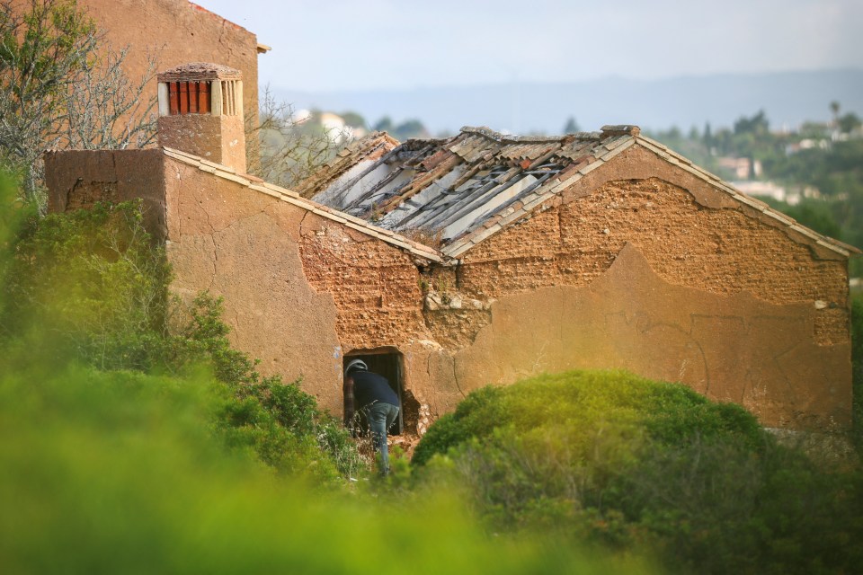 A person inspecting a dilapidated building.