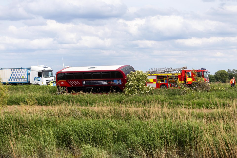 Double-decker bus and car accident scene with emergency services.