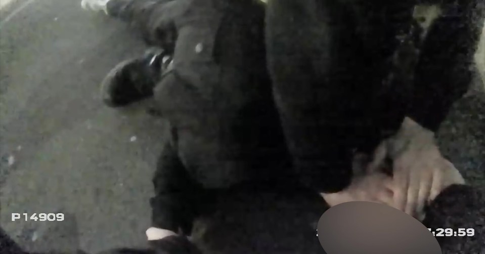 Video still of a police officer arresting a person.
