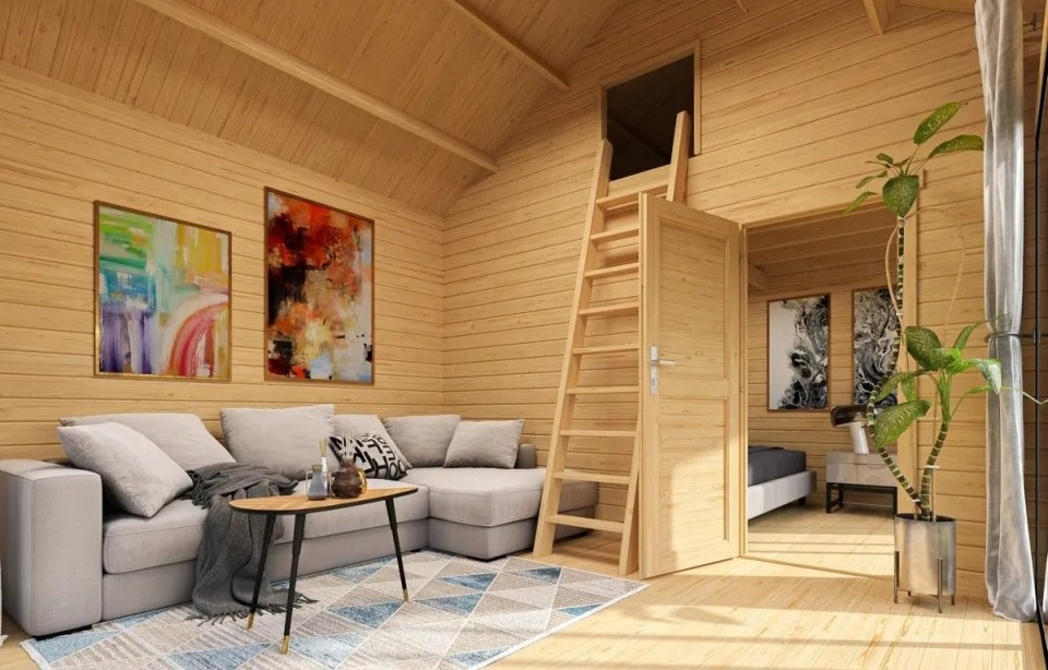 Interior view of a log cabin with a loft bedroom and living area.
