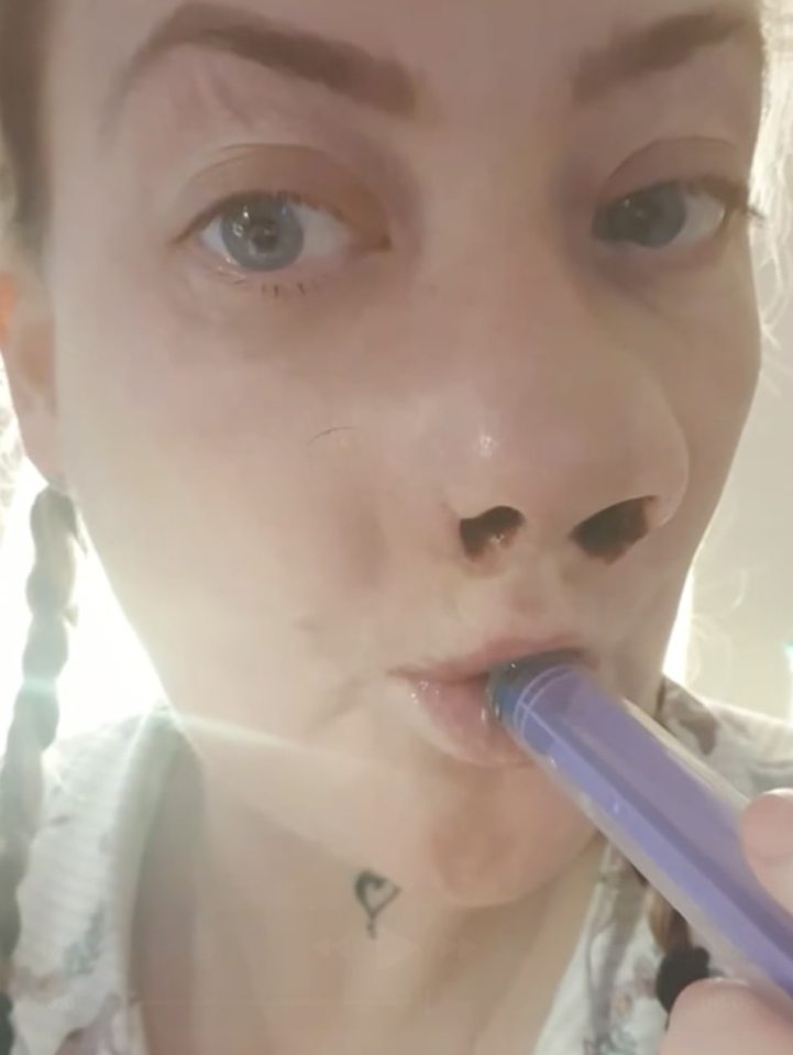 Close-up of a woman receiving an injection in her mouth.