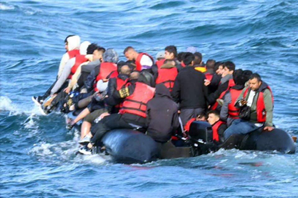 Overcrowded boat carrying migrants at sea.
