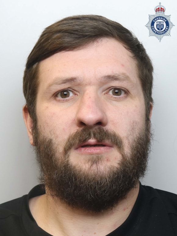 Mugshot of a man with a beard.