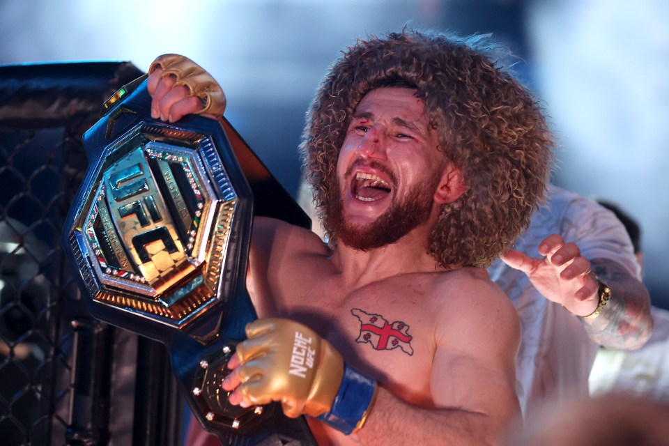 Merab Dvalishvili holding the UFC bantamweight championship belt.