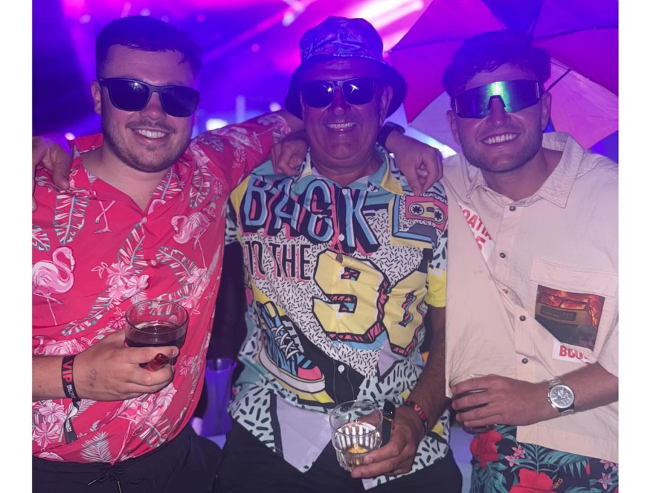 Three men posing together at a party.