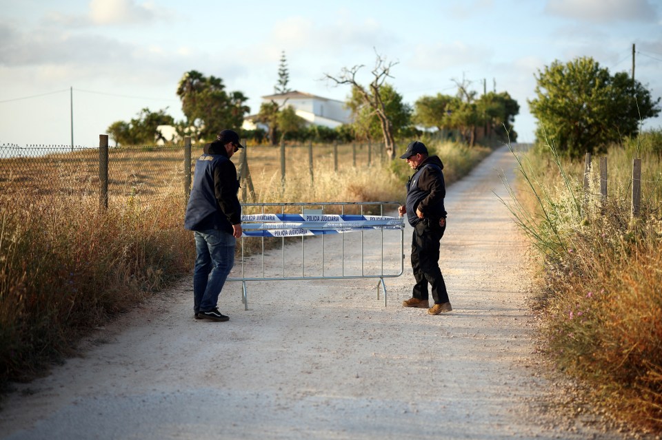 Police officers moving a barrier on a road.